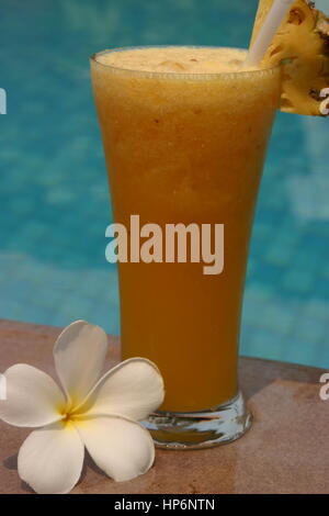 Le jus d'orange fraîchement pressé dans un verre au bord de la piscine Banque D'Images