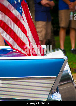 Détail d'une voiture classique avec un drapeau américain attaché au volant dans un défilé du 4 juillet. Banque D'Images