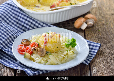 Chaudrée de pommes de terre gratin de raviolis au fromage et bacon servi sur salade chaude Banque D'Images