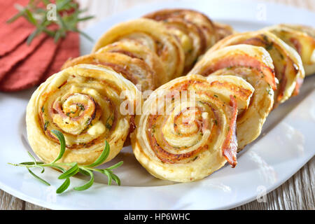 Rouleaux au four pâte feuilletée copieux avec du jambon, fromage à la crème, le parmesan et fines herbes Banque D'Images