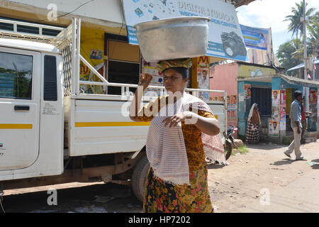 Mumbai, Inde - le 3 novembre 2015 - Femme transporte sur sa tête dans les rues bondées et la circulation à Mumbai avec les tuk tuk et les taxis Banque D'Images