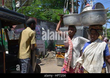 Mumbai, Inde - le 3 novembre 2015 - Les femmes transportant des paquets sur leurs têtes dans les rues bondées et la circulation à Mumbai avec les tuk tuk et les taxis Banque D'Images