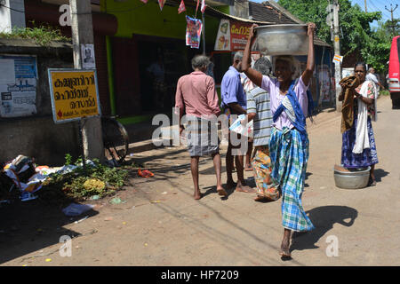 Mumbai, Inde - le 3 novembre 2015 - Femme transporte sur sa tête dans les rues bondées et la circulation à Mumbai avec les tuk tuk et les taxis Banque D'Images