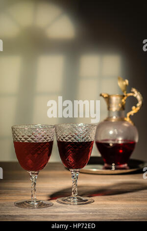 Deux verres anciens remplis de claret à carafe en arrière-plan Banque D'Images