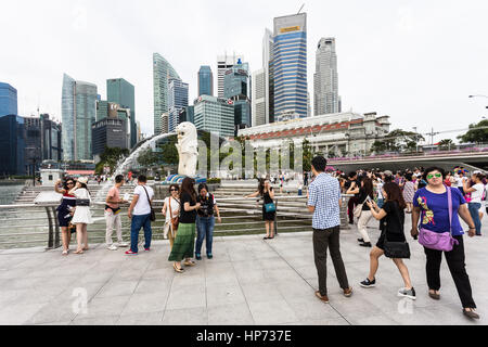 Singapour, Singapour - Septembre 21, 2016 : les touristes de prendre des photos en face de la célèbre skyline de Singapour et la statue du Merlion dans la Marina Bay. Banque D'Images