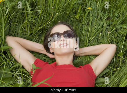 Parution du modèle, Junge Frau, 30, liegt in der entspannt Fruehlingswiese - woman relaxing in spring meadow Banque D'Images