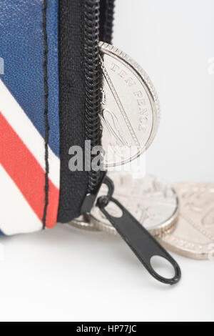 Porte-monnaie Union Jack à fermeture à glissière avec pièces de monnaie britanniques/pièces de monnaie visibles ou débordent. Métaphore les dépenses des ménages britanniques, le budget ou la hausse des prix. Banque D'Images