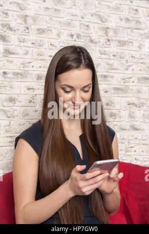 La belle jeune fille aux cheveux long parle au café par téléphone Banque D'Images