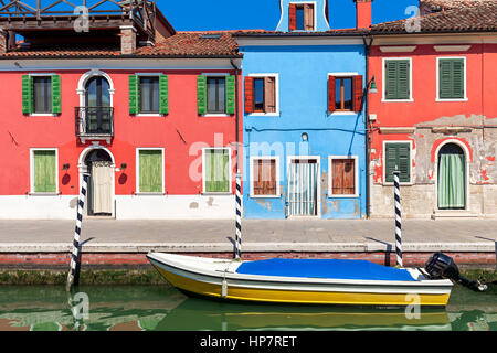 Voile sur petit canal en face de vieille maisons colorées sur l'île de Burano en Italie. Banque D'Images