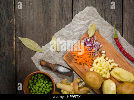 Ingrédients pour soupe aux légumes. Légumes Concombre oignons pommes de terre pois carottes épices dans la section sur l'arrière-plan en bois gris Banque D'Images