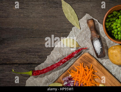 Ingrédients pour soupe aux légumes. Légumes Concombre oignons pommes de terre pois carottes épices dans la section sur l'arrière-plan en bois gris Banque D'Images