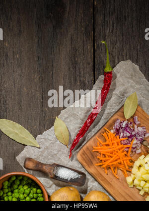 Ingrédients pour soupe aux légumes. Légumes Concombre oignons pommes de terre pois carottes épices dans la section sur l'arrière-plan en bois gris Banque D'Images