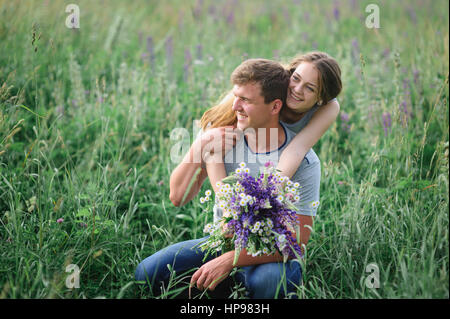 Jeune couple embracing on summer meadow Banque D'Images