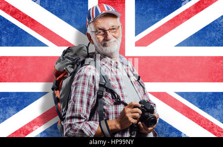 Photographe touristique principal avec sac à dos et appareil photo numérique, il porte un drapeau britannique cap Banque D'Images