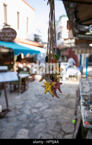 Pack fo multicolore en forme des étoiles de seastar souvenires avec accrochage sur la rue touristique floue en arrière-plan Kash Antalya Banque D'Images