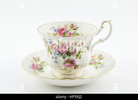 Tasse et soucoupe antique vide avec décoration rose isolé sur blanc - thé anglais Banque D'Images