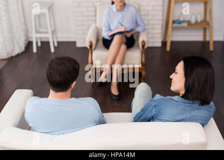 La visite d'un psychologue. Déprimé malheureux jeune couple assis en face d'un psychologue et décrire leurs problèmes tout en ayant un rendez-vous Banque D'Images