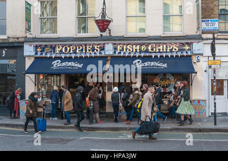 Une scène de rue animée avec les clients et les passants à l'extérieur du poisson et coquelicots friterie, Hanbury Street, London E1. Banque D'Images