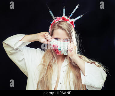 Costume Halloween d'une infirmière folle avec couronne faite de seringues et d'une seringue dans la main Banque D'Images