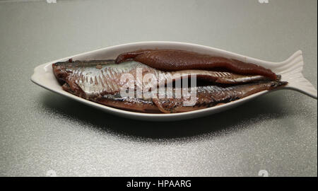 Hareng salé sur une plaque sous la forme de poissons Banque D'Images