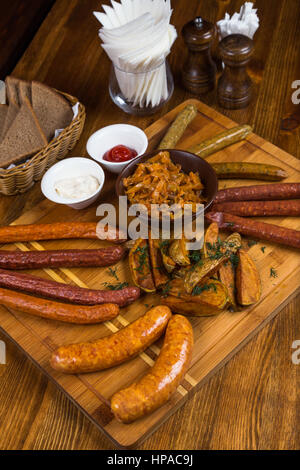 Assortiment de saucisses chaudes servant sur planche de bois dans le Banque D'Images