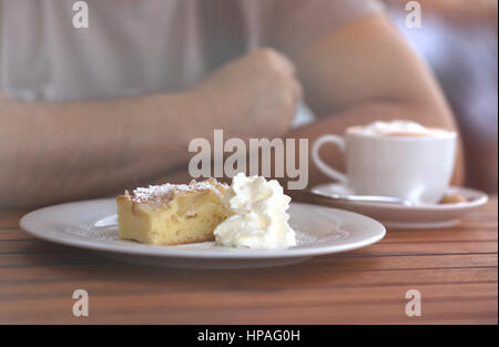 Gros plan sur l'homme assis dans le café après avoir morceau de gâteau sucré crémeux Banque D'Images