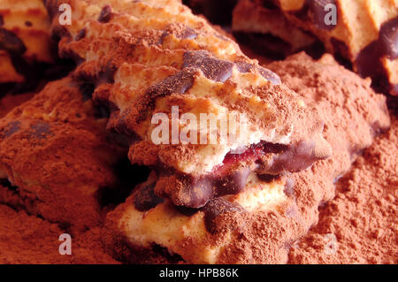 Pile de biscuit avec de la confiture et du chocolat cerise sur la dispersion de la poudre de cacao de près. Banque D'Images