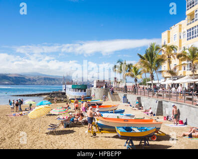 Les gens de soleil près de bateaux de pêche colorés à La Puntilla sur la plage de Las Canteras à Las Palmas, Gran Canaria, Îles Canaries, Espagne Banque D'Images