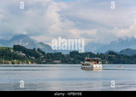 Lucerne, Suisse - 24 mai 2016 : des passagers de croisière voile en face de caché par les nuages montagnes des Alpes couvertes de neige pics sur le lac de Lucerne, Suisse Banque D'Images