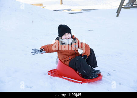 Enfant Garçon jouant et riant on snowy winter walk dans la nature. Givre hiver saison.cute little boy avec traîneaux soucoupe en plein air sur journée d'hiver, trajet en bas Banque D'Images