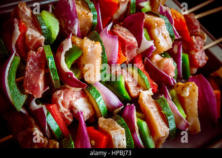 Rangées de façon ordonnée sur la viande.crache en bois coloré et divers légumes sains dans un grill barbecue. Shish kebabs faite avec des champignons,poivrons,cherry toma Banque D'Images