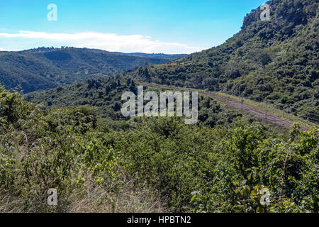 L'exécution de la voie rurale à travers la végétation, collines et vallées contre blue skyline at Shongweni, Afrique du Sud, Banque D'Images