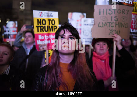 Londres, Royaume-Uni. 20 février 2017. De personnes se sont réunies à la place du Parlement pour protester contre l'Brexit et le projet de Donald Trump de sa visite d'état en Bretagne et ses politiques d'immigration inéquitable. Une jeune femme concernée est d'écouter et de regarder des événement conférenciers parler. Dans l'arrière-plan, un manifestant est holding a placard lecture : 'L'histoire vous regarde'. Credit : ZEN - Zaneta Razaite/Alamy Live News Banque D'Images