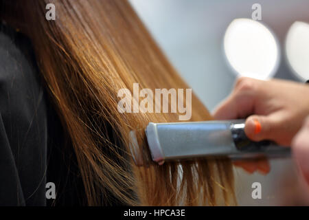 Coiffure coiffure organiser par lisseur Banque D'Images