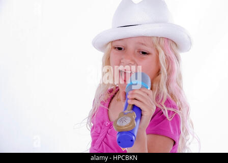 Maedchen, 7, singt mit Mikrofon - girl singing with microphone Banque D'Images