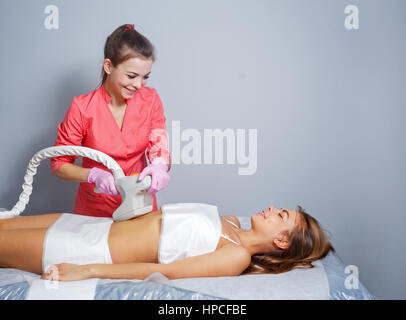 Massage sous vide de l'abdomen d'une jeune fille. Cosmétologie instrumentale. Studio Spa. Rajeunissement et raffermissement de la peau. Banque D'Images