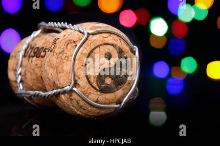 Bouchon de Champagne avec la forme d'un symbole Ying Yang brûlé dans les feux colorés et flou en arrière-plan.(série) Banque D'Images