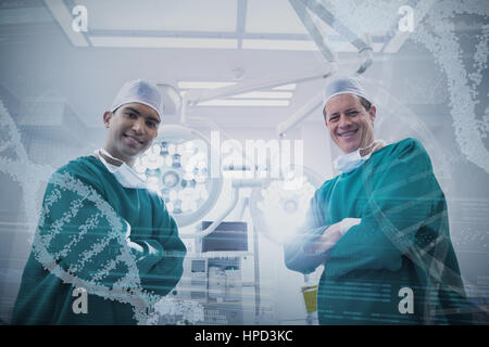 Vue panoramique de l'information modèle helix sur écran de l'appareil contre portrait of surgeons standing en salle d'opération Banque D'Images