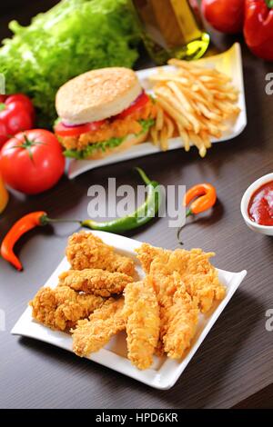 Lanières de poulet pané avec des sauces, tomates, poivrons. Banque D'Images