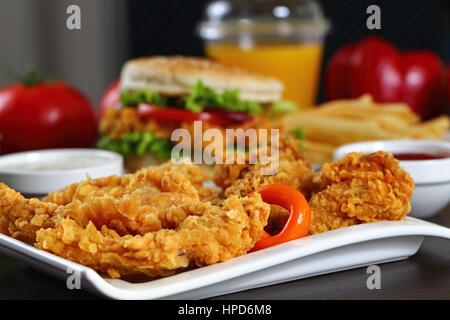 Lanières de poulet pané avec des sauces, tomates, poivrons. Banque D'Images