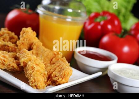 Lanières de poulet pané avec des sauces, tomates, poivrons. Banque D'Images