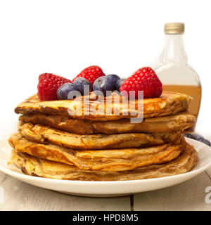 Une photo de la place des crêpes maison, décorée avec des bleuets et framboises fraîches, avec une bouteille de sirop d'érable trouble générique dans le Banque D'Images