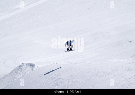 Snowboarder sautant dans parc acrobatique à ski sur sun journée d'hiver. Montagnes du Caucase, région Chelyabinsk. Banque D'Images