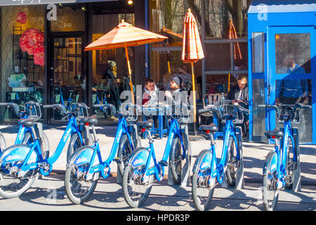 Diners en plein air à l'extérieur d'un café en hiver et une ligne d'Citibike la location de vélos Banque D'Images