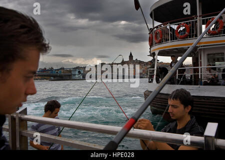 Les pêcheurs sur la Corne d'or, dans le district d'Eminonu près de pont de Galata, en arrière-plan quartier de Beyoglu, Istanbul. La Turquie Banque D'Images