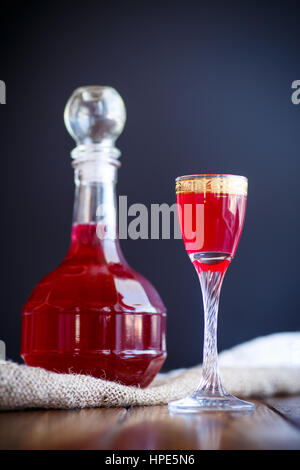 Pamplemousse doux cordial alcoolique dans la carafe avec un verre sur un tableau sombre Banque D'Images