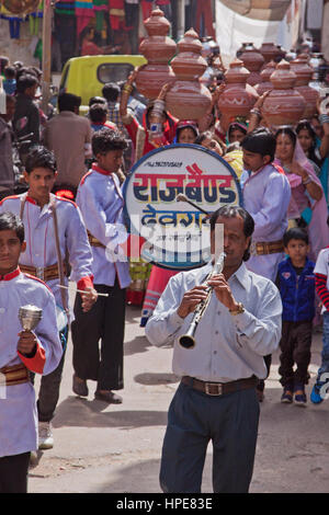 Une fanfare en tête une femme mariage procession à travers les rues de Deogarh, Inde. Les femmes suivant derrière faire vaisselle symbolique sur leurs têtes Banque D'Images