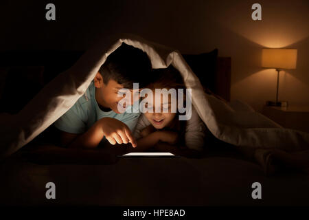 Frère et soeur de la section page sharing digital tablet Banque D'Images