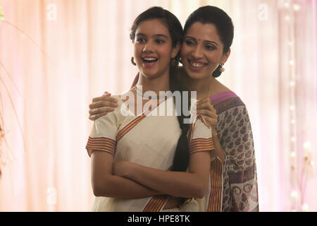 Smiling teenage girl in sari avec sa mère Banque D'Images