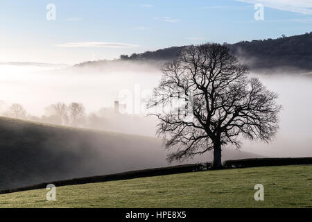 Mist passe au-dessus d'une combe ou coombe une vallée contenant le village de Dunsford dans la Teign Valley,s/n et de chaume,blanchis Dartmoor National Park Banque D'Images